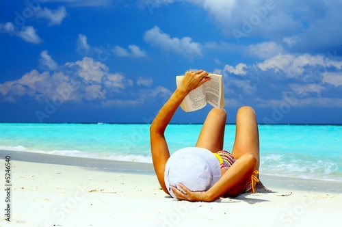 Young women is reading on the coral beach