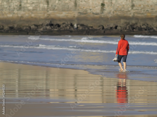 Mujer paseando por la playa photo