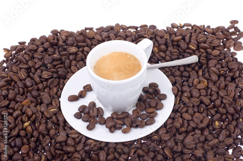 Espressotasse mit Löffel in Kaffeebohnenmeer