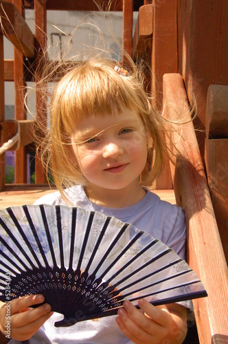 curious blond girl with fan