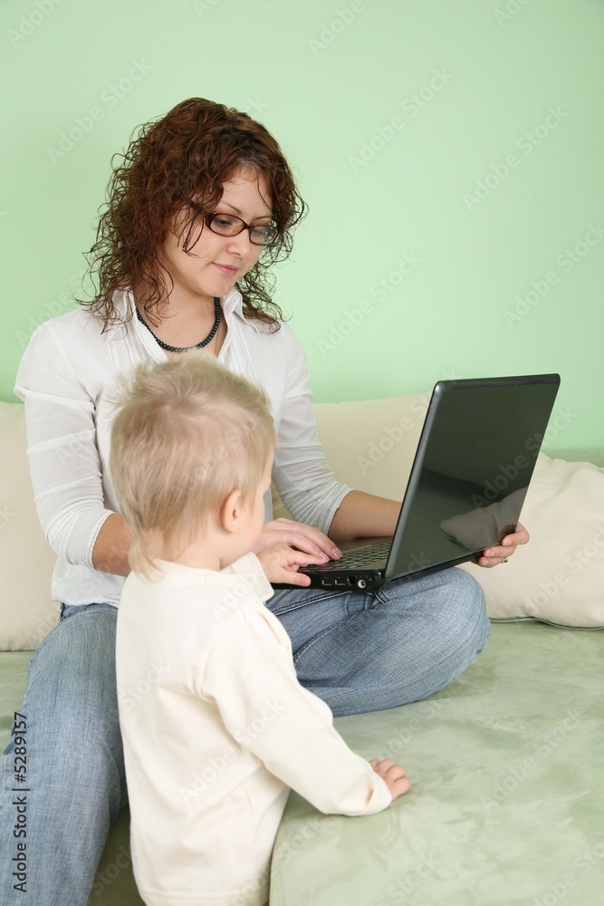 Young mother with his son and notebook Young mother with his son and notebook