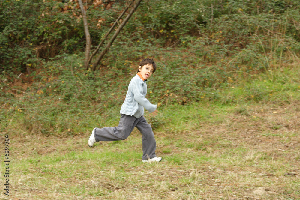 petit garçon avec des lunettes entrain de courir