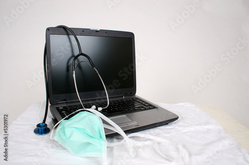 Laptop with surgical mask and sethoscope photo