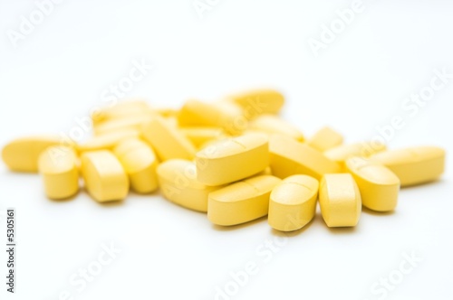 yellow pills over white background
