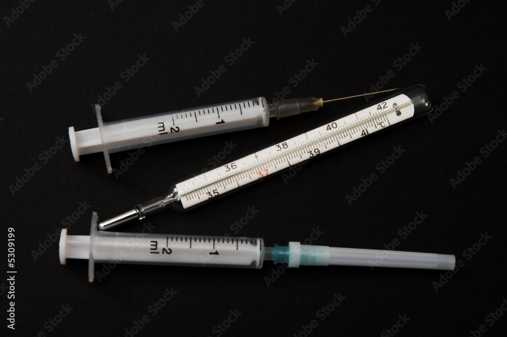 syringes and thermometer over black background syringes and thermometer over black background