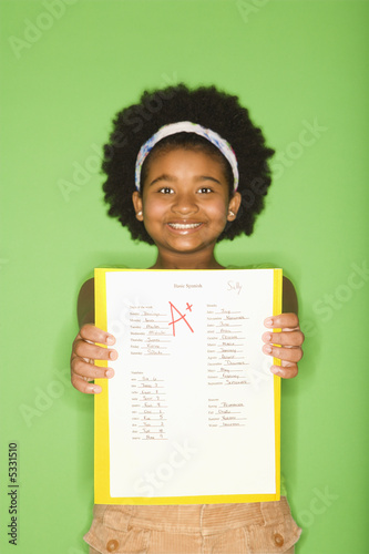 Girl holding out graded school assignment smiling proudly. photo