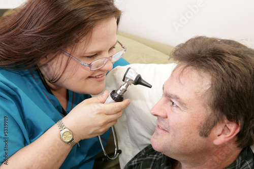 Home health nurse checking her patient's  eyes photo