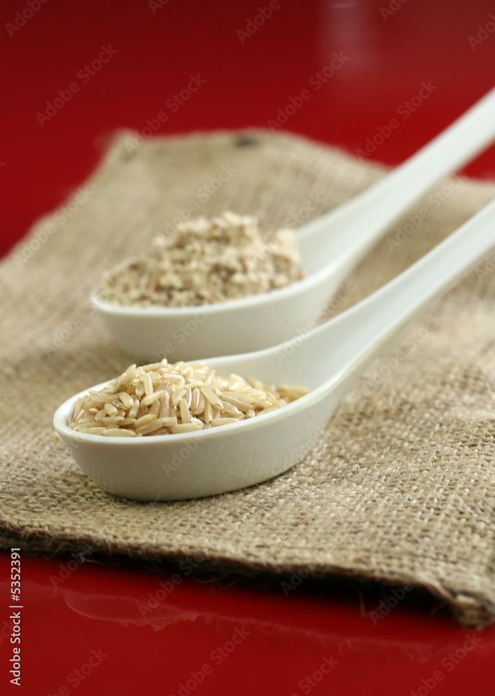 Brown rice and whole wheat flour on a red background Brown rice and whole wheat flour on a red background