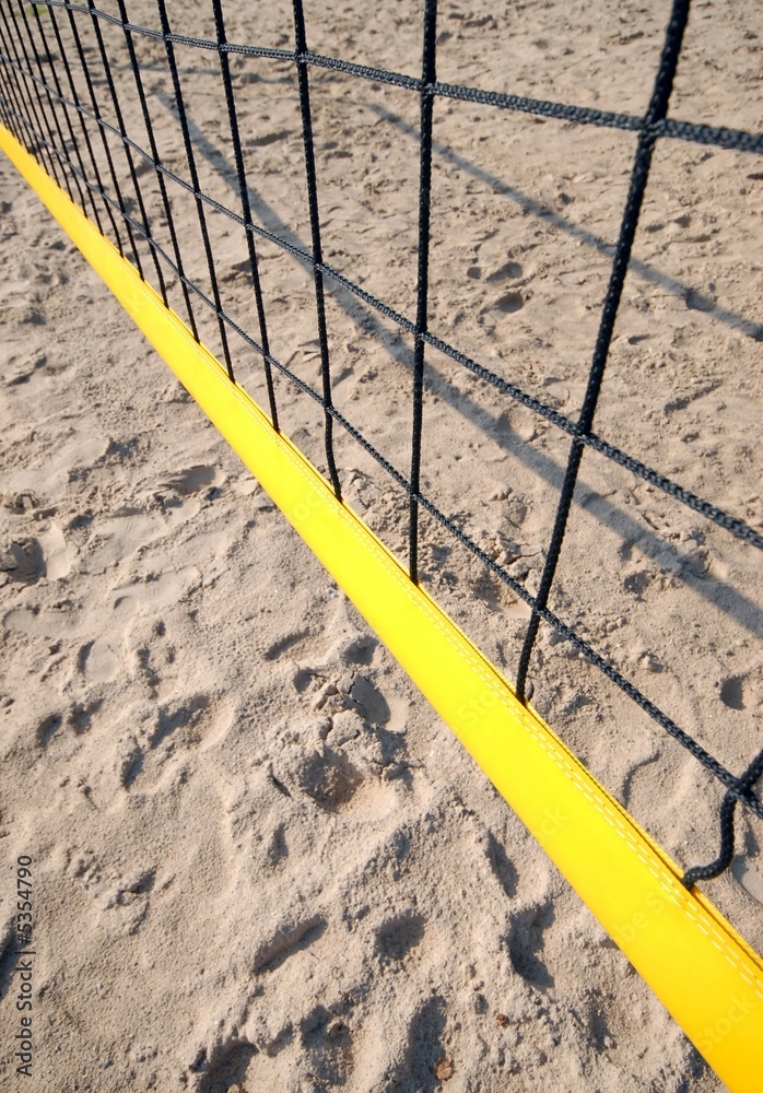 yellow volleyball net shot from above, visible sand