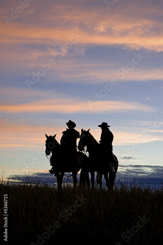 Cowboys silhouettes against a dawn sky. Horse ranch in Montana © outdoorsman