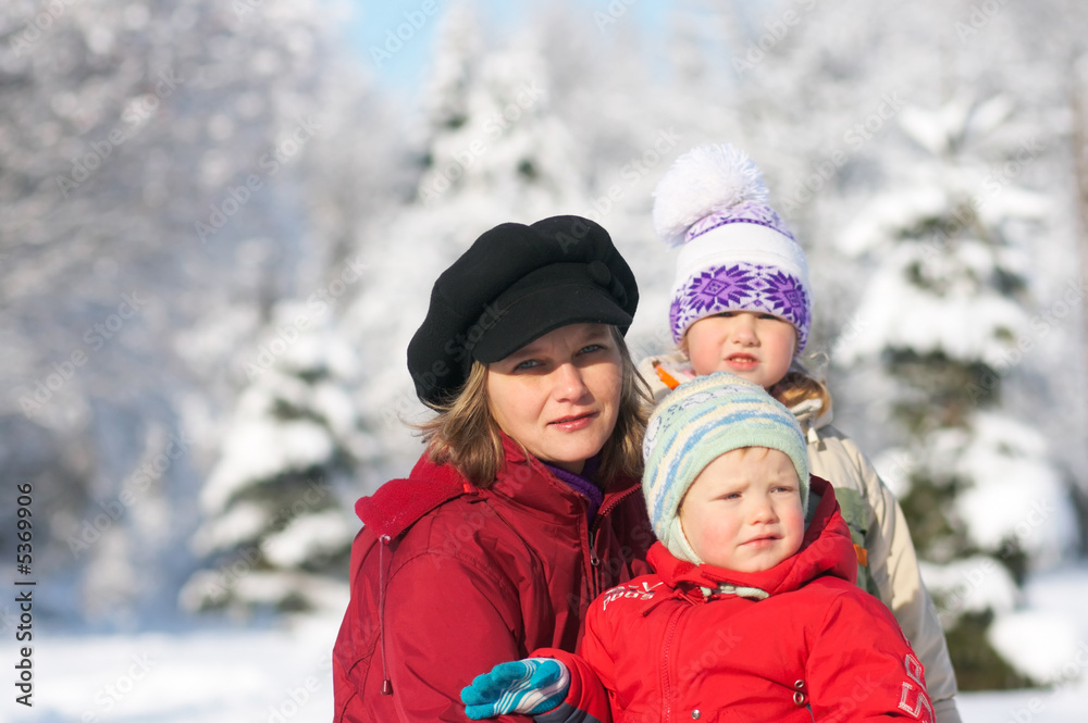 Happy family (mother with boy and girl) in winter  city park