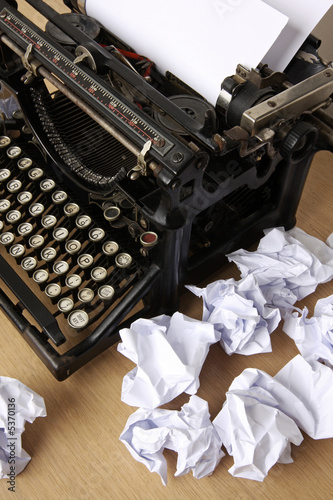 Typewriter with paper scattered - conceptual image