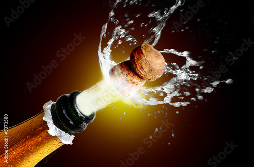 Close up of champagne cork popping photo