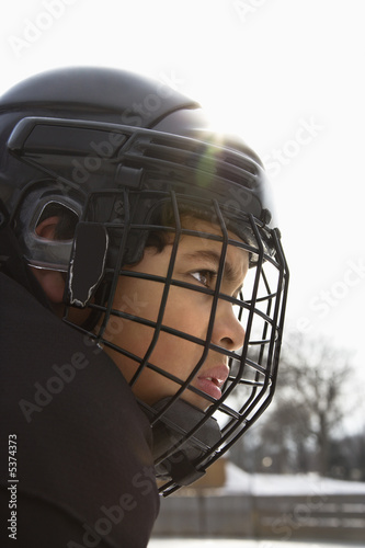 Close up of ice hockey player boy in cage helmet.