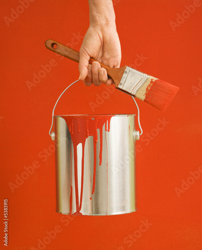 Fototapeta Naklejka Na Ścianę i Meble -  Caucasian female hand and leg holding paint can and paintbrush.