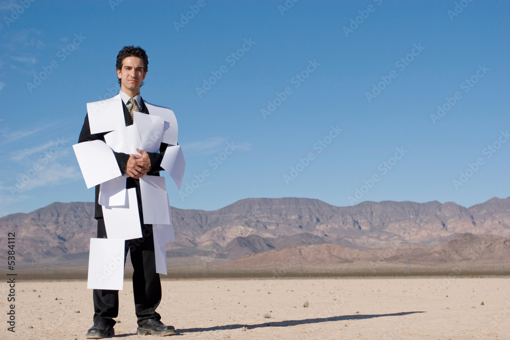 Businessman covered with white papers Businessman covered with white papers