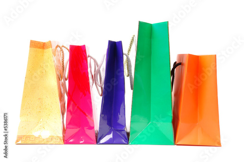 Line of five colorful paper shopping bags over white