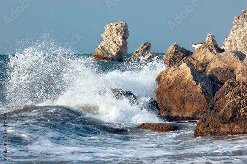 blue sea and rocks storming in light of sunset