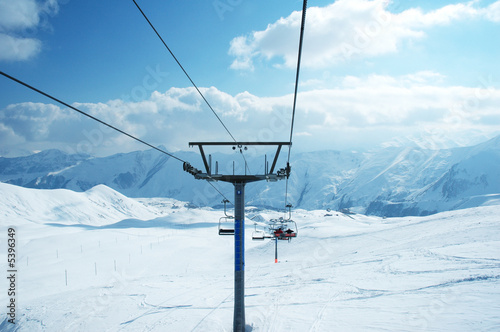 Ski lift chairs on bright winter day photo