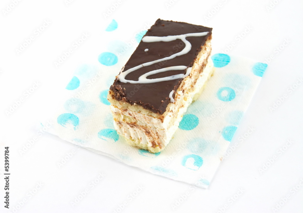 Cake under a layer of the chocolate, laying on a napkin Cake under a layer of the chocolate, laying on a napkin
