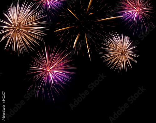 Multiple fireworks exploding with bright trails