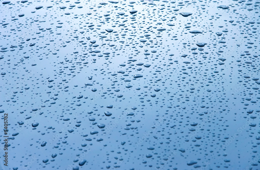 Water drops on car hood. Blue tint.