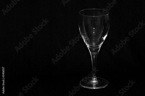 single wine glass shot against a black background