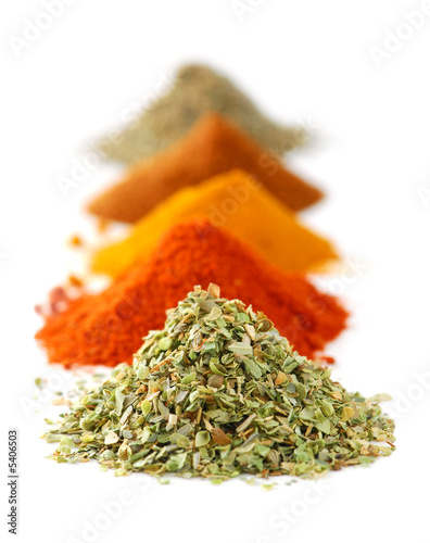 Heaps of various ground spices on white background