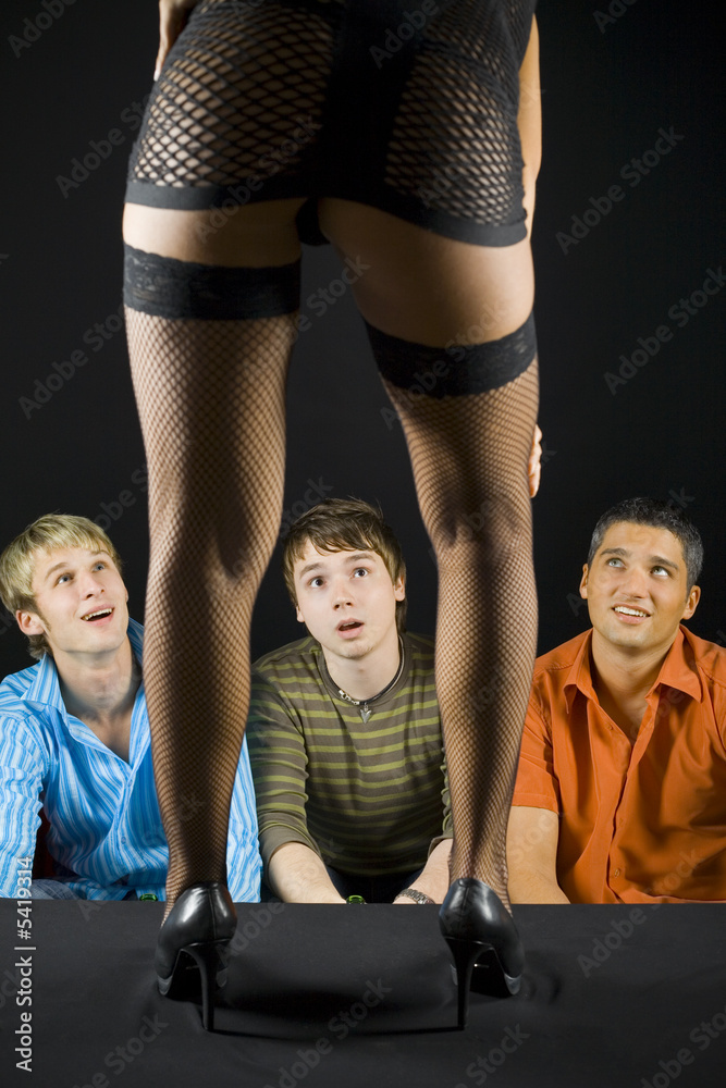 Three men sitting in front of woman in dark room Three men sitting in front of woman in dark room