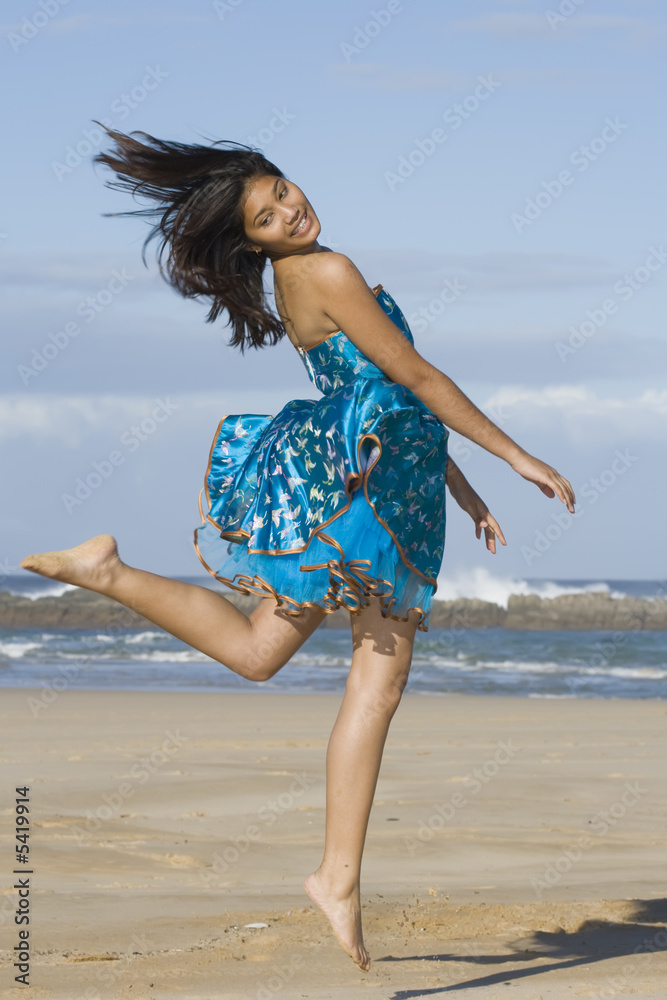 Girl in asian inspired dress jumping into the air