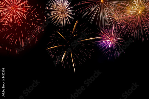 Multiple brightly coloured fireworks exploding photo