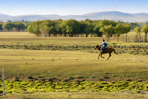 A man riding horse at the grassland in Inner Mongolia.