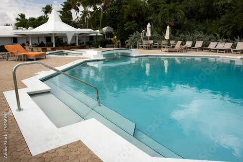 swimming pool with loungers with no people in sight © Robert Hackett