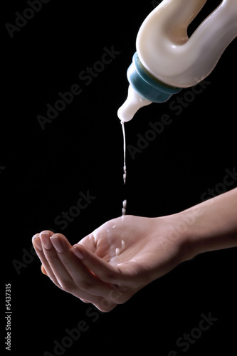 milk from the bottle is droping on hand photo