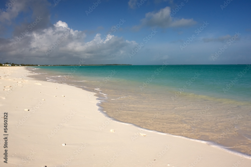 turquoise sea lapping on beach with blue sky