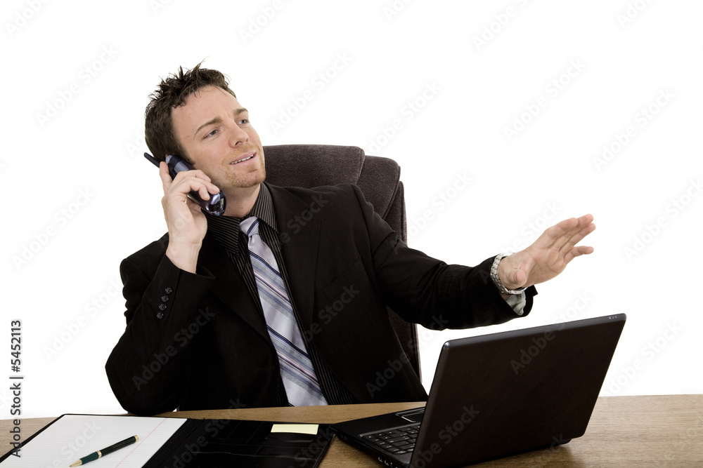 Caucasian businessman setting a desk talking on the phone Caucasian businessman setting a desk talking on the phone