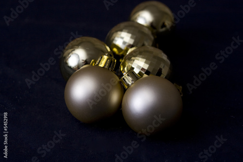 Close-up of gold Christmas balls on a black background.