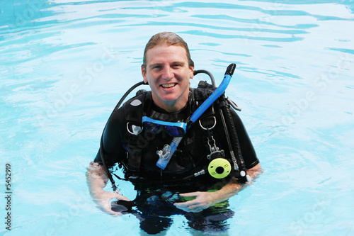Happy scuba diver in the swimming pool.