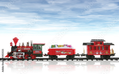A colorful holiday Christmas train in the snow with a cloudy sky