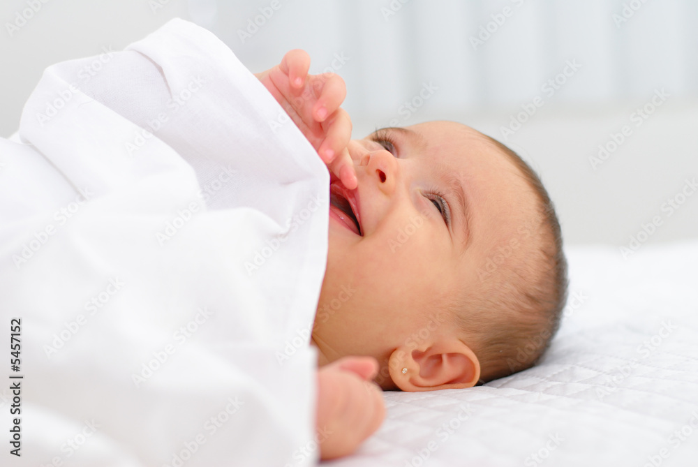 Photo of a baby smiling lying in the bed. Photo of a baby smiling lying in the bed.