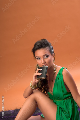 Young woman drinking alcohol from hip flask