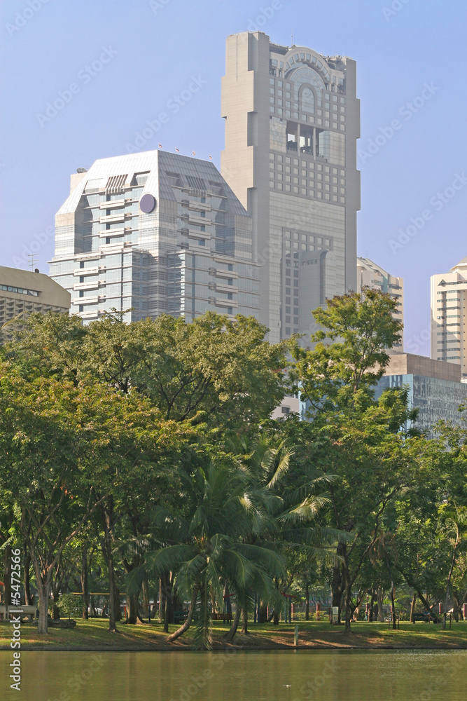 Obraz premium Modern office blocks with a lush tropical park in the foreground