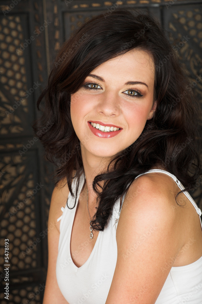 Young adult brunette woman with a white top and brown hair Young adult brunette woman with a white top and brown hair