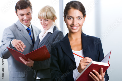 Portrait of executive secretary holding the notepad and pencil  photo