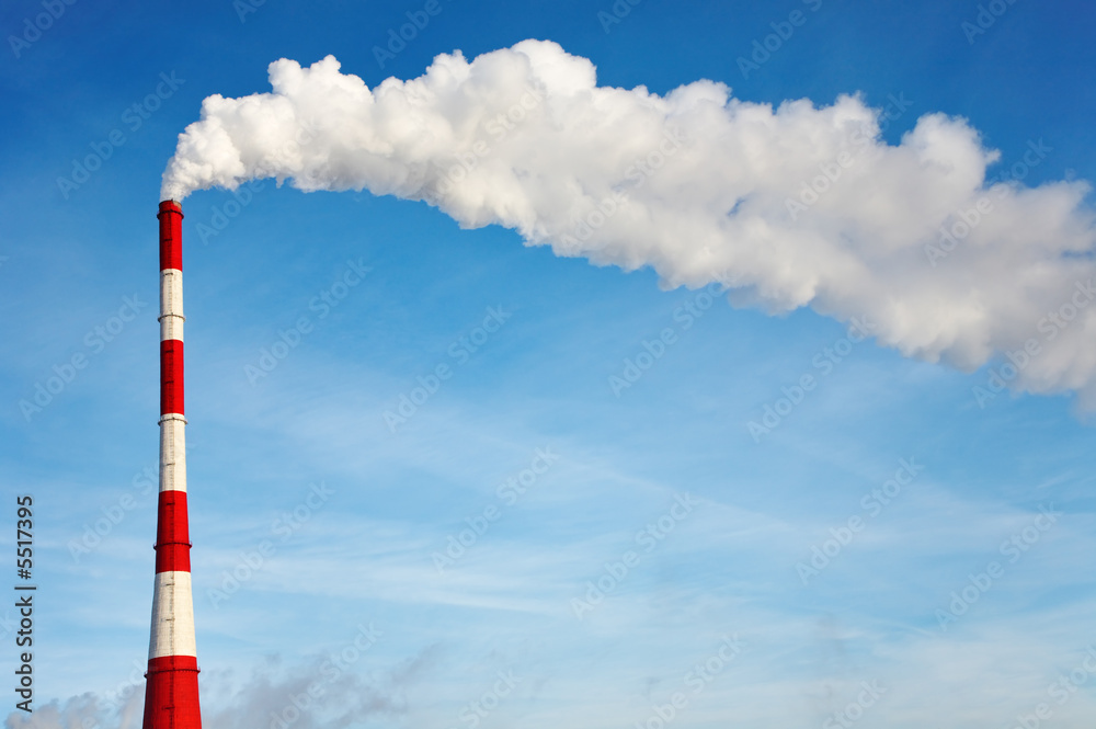 Air polluting smokestack against blue sky