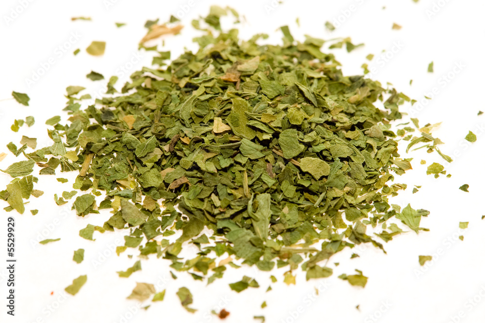 Dried, crushed parsley flakes isolated on white. Dried, crushed parsley flakes isolated on white.