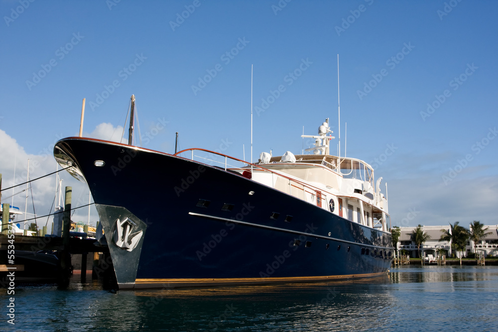 blue hull luxury motor yacht tied to dock