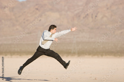 Happy businessman jumping in air