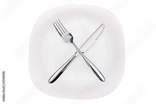 Fork and knife on a dish isolated on white background