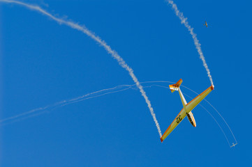 Fotobehang Luchtsport Stuntvliegtuig met witte rookspoor  © psamtik